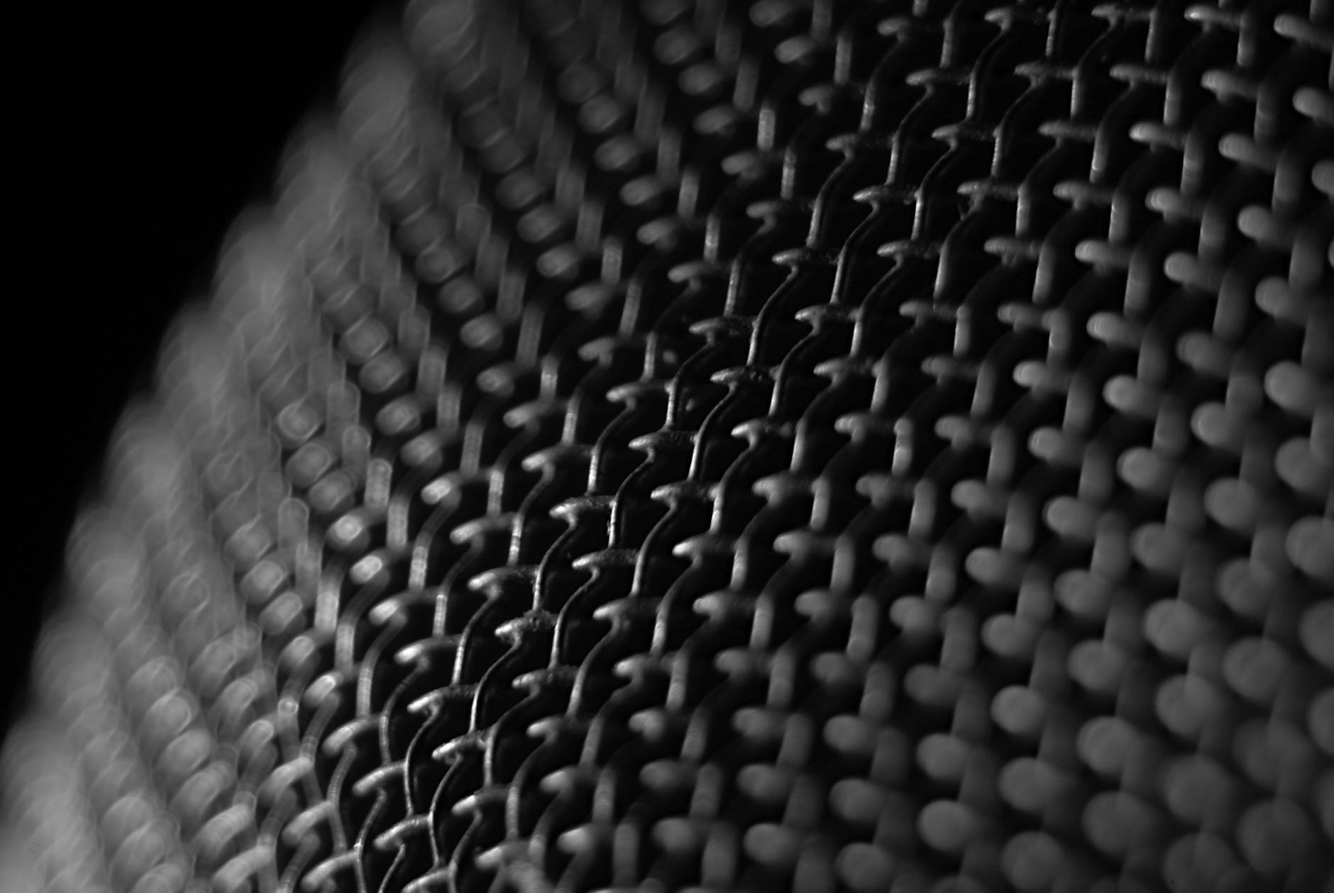Close-up of a French Press metal mesh filter, showing its intricate design and the small gaps through which coffee oils and fine particles can pass.