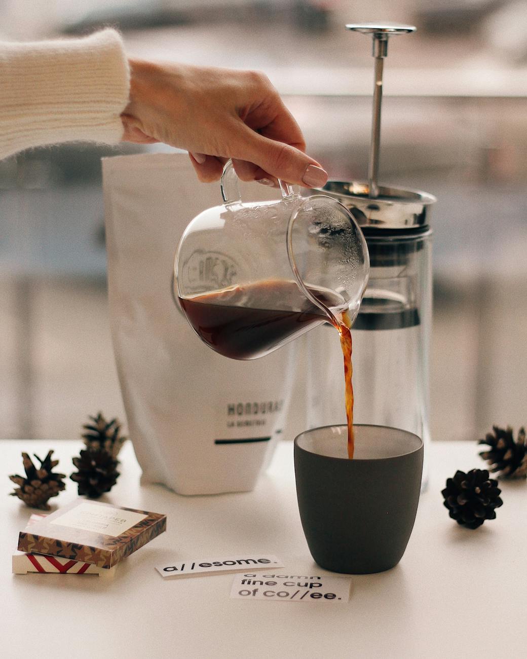 A clean, shiny French Press with freshly brewed coffee, ready to be poured, on a minimalist kitchen counter.