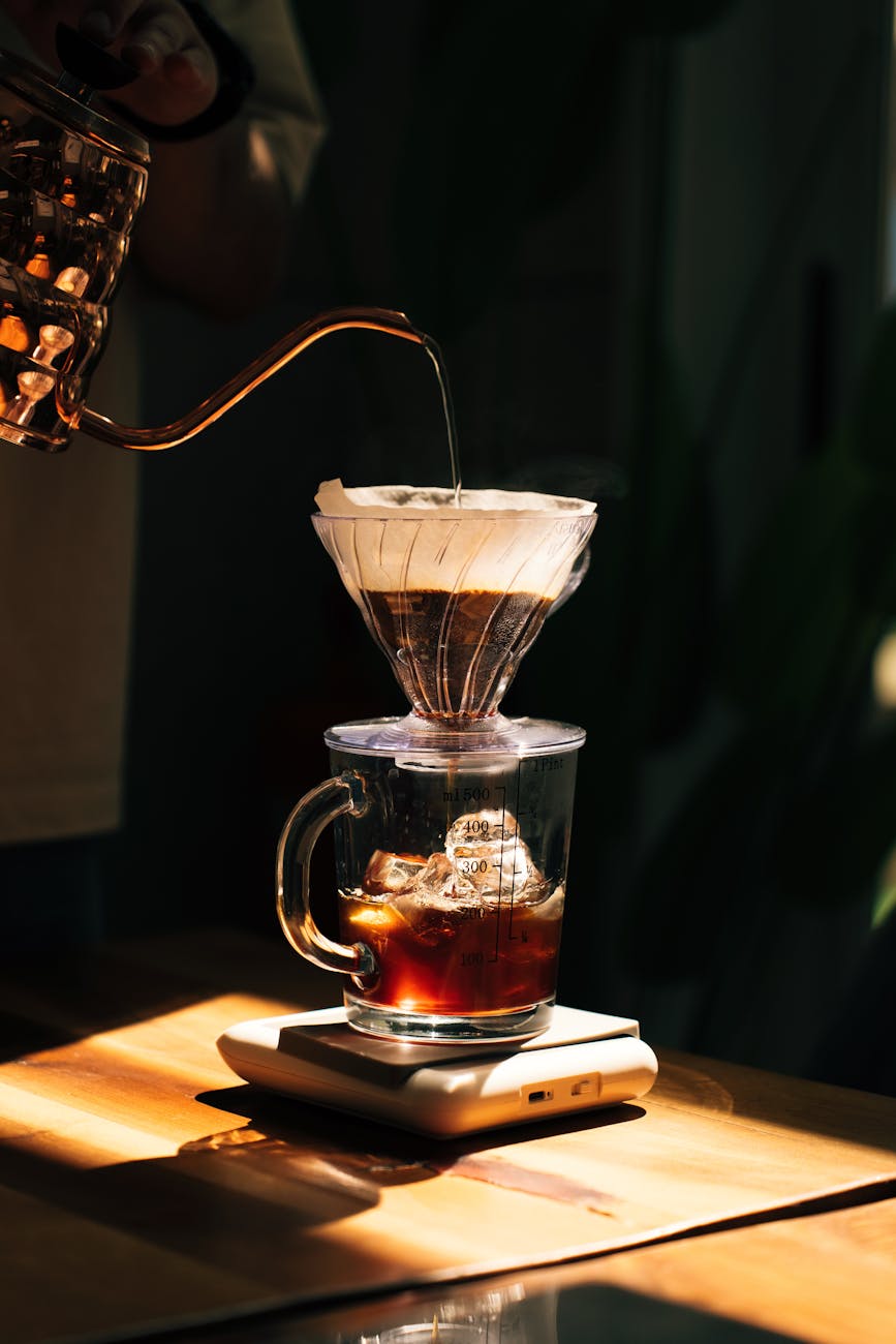 A close-up of a coffee scale with a pour-over dripper on top, precisely measuring coffee grounds and water, emphasizing the importance of ratio.