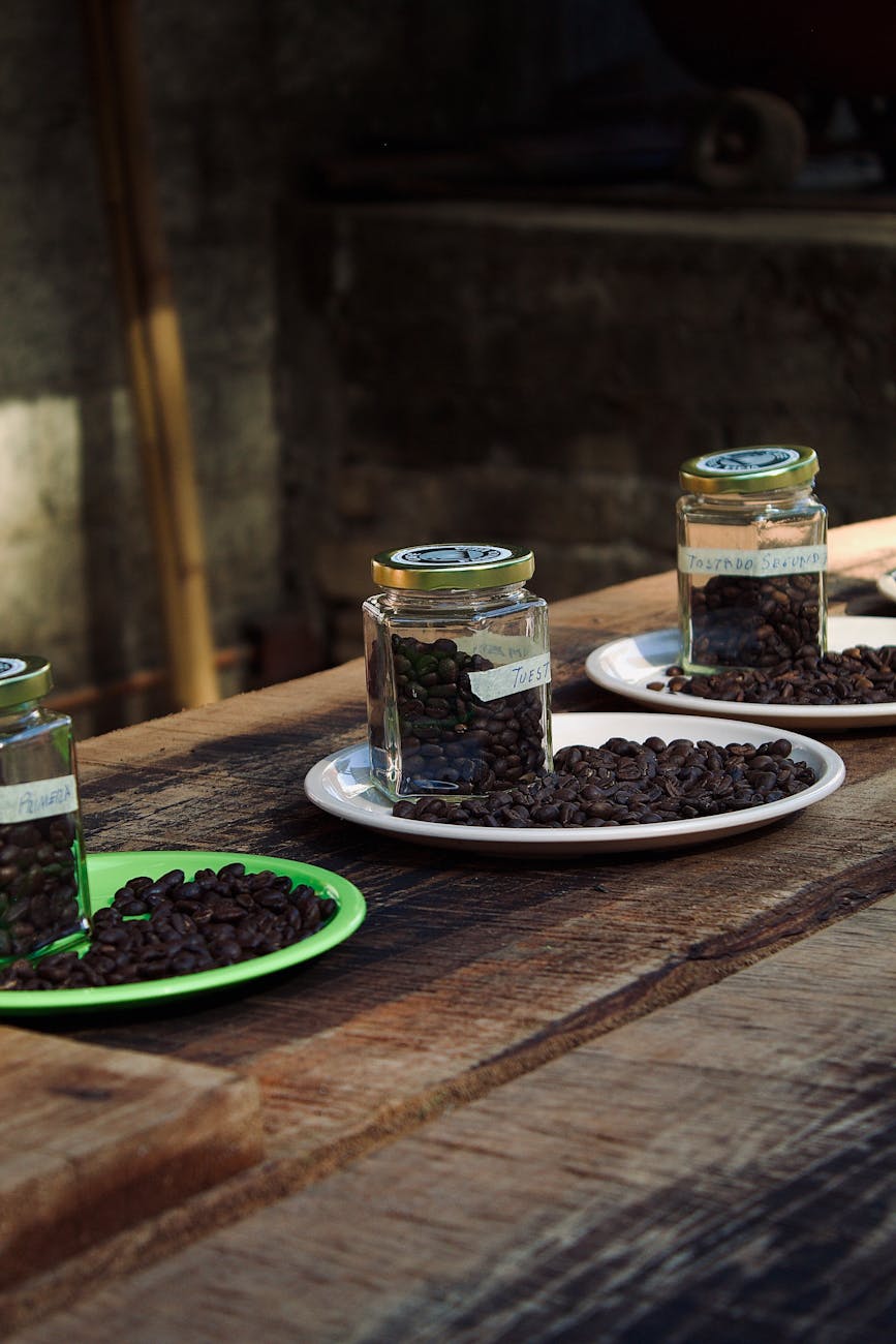 A curated collection of different coffee bean varieties (light, medium, dark roasts) displayed in clear jars, labeled with origin and roast date, emphasizing the importance of freshness and bean type.