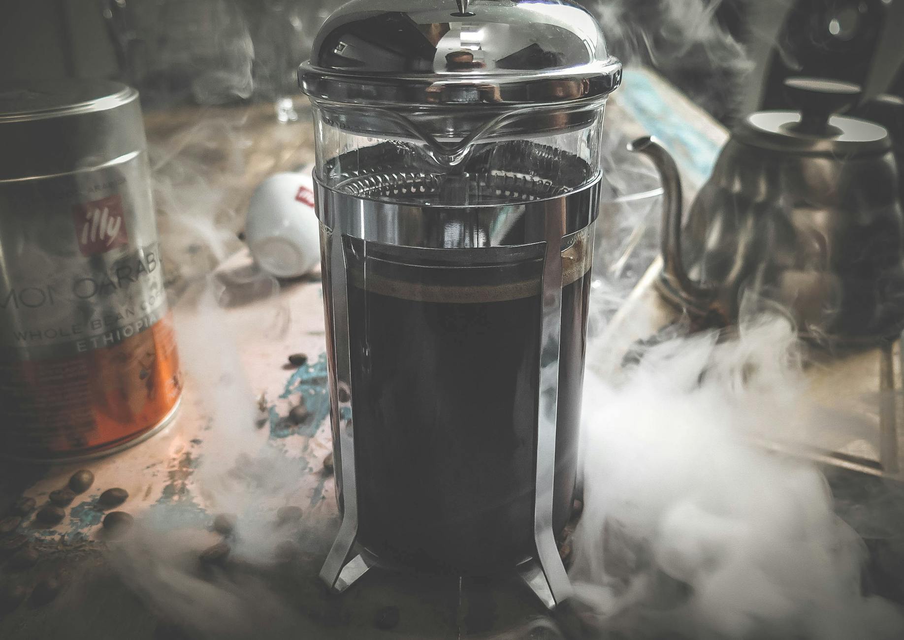 Side-by-side comparison of a French Press and a Drip Coffee machine, both actively brewing coffee, with fresh coffee beans scattered nearby. The image should convey warmth and the allure of freshly brewed coffee.