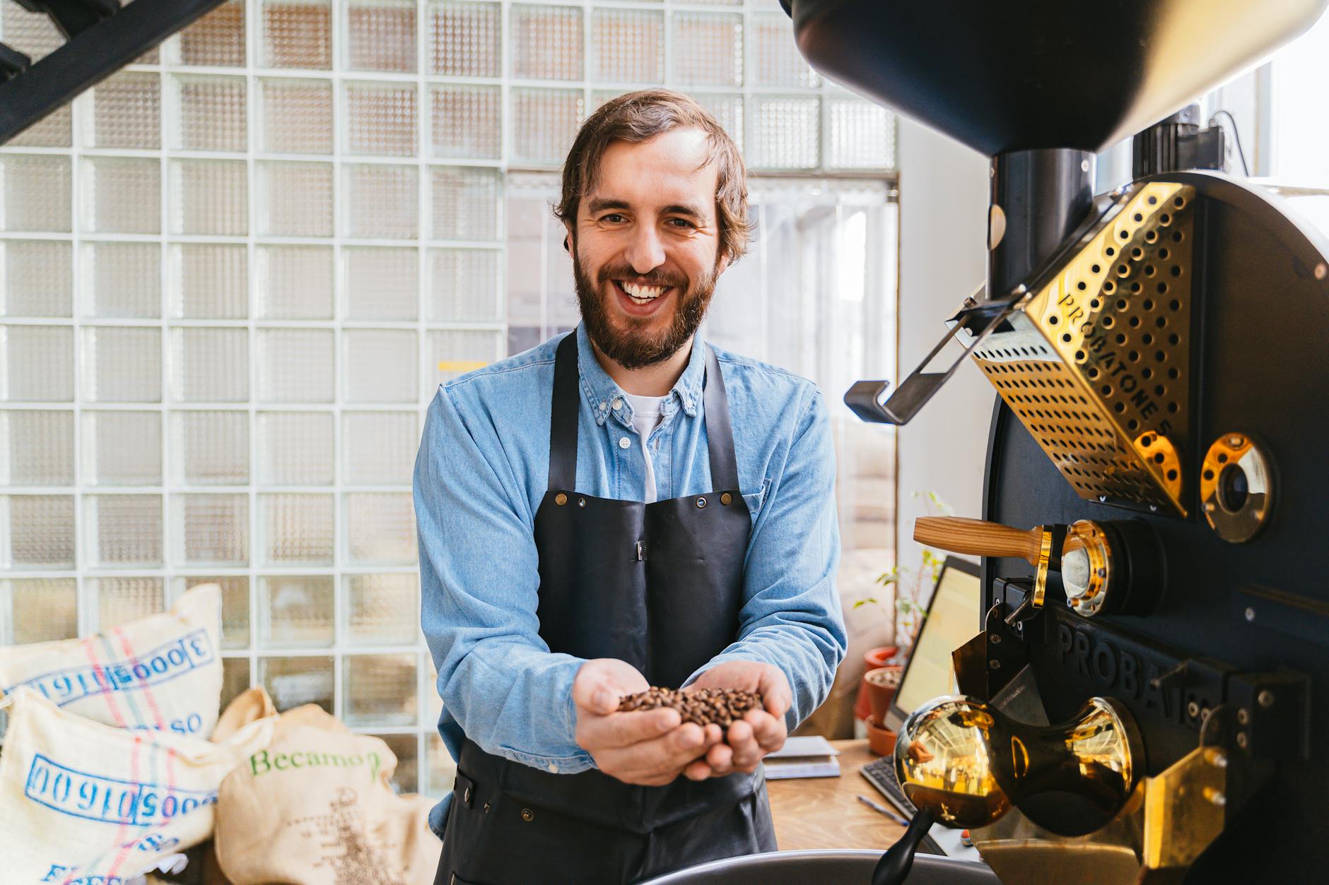 A person evaluating different coffee grinders in a store, holding a handful of coffee beans, making an informed decision.