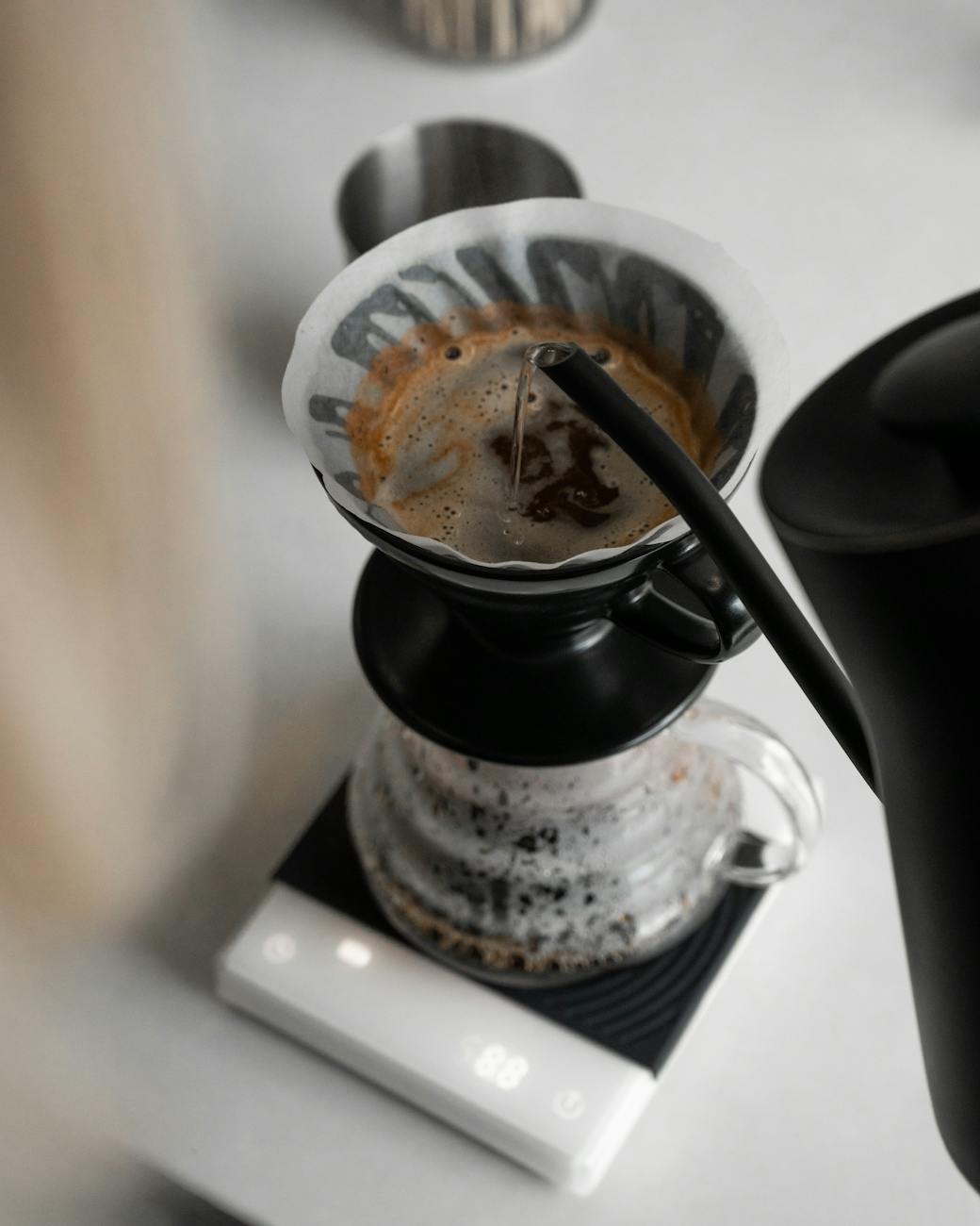 A versatile coffee scale effortlessly switching between being used for espresso on a machine and then placed under a pour-over dripper on a stand, split image or sequence, demonstrating adaptability, clean modern kitchen setting